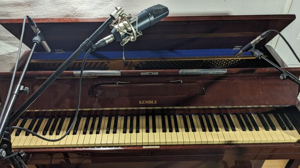 image of a Kemble upright piano with the top open, 3 microphones used, 2 Rhode NT5s and one U87